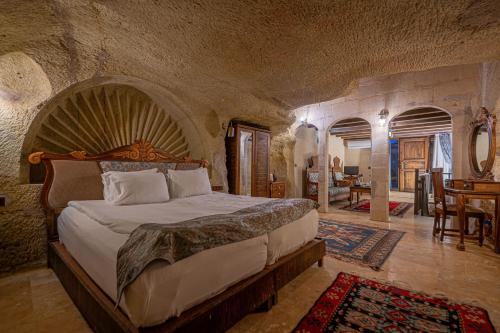 a bedroom with a large bed in a stone room at Gamirasu Village House in Nevsehir
