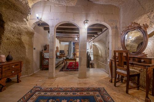 a living room with a mirror and a table and a chair at Gamirasu Village House in Nevsehir