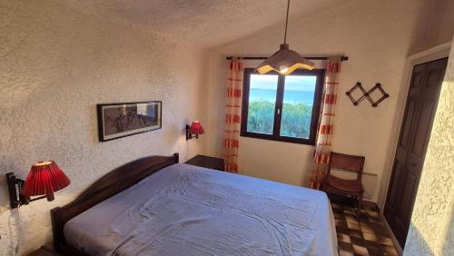 une chambre avec un lit et une fenêtre dans l'établissement Villa Nitiola Plage de Palombaggia, à Bocca del Oro