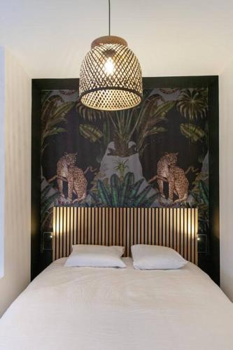 - une chambre avec un grand lit et un lustre dans l'établissement Le Jungle - Votre séjour tout confort - Fibre, à Châteauroux