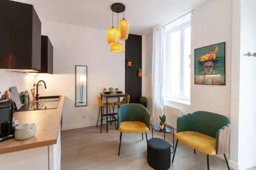 Il comprend une cuisine et un salon avec des chaises et une table. dans l'établissement Le Jungle - Votre séjour tout confort - Fibre, à Châteauroux