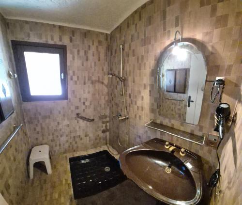 La salle de bains est pourvue d'une baignoire, d'un miroir et d'un lavabo. dans l'établissement Villa Nitiola Plage de Palombaggia, à Bocca del Oro