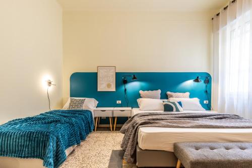 a bedroom with two beds and a blue wall at HouSmart Emilia Levante 98 in Bologna