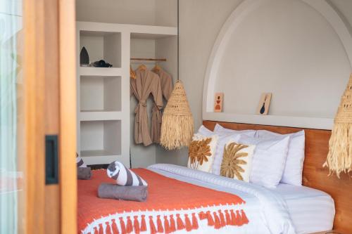 a bedroom with a bed with an orange blanket at Villa Nebula Nearby Soma in Canggu