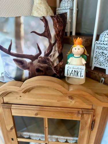 a stuffed deer with a sign on a table at B&B Apart Hotel Goldener Hahn - Hygge Pool & Sauna in Baiersbronn