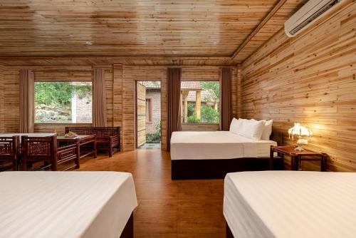 a room with two beds and a table and chairs at Tam Coc Rocky Bungalow in Ninh Binh
