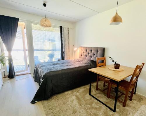 a bedroom with a bed and a wooden table at Cozy and relaxing apartment in Ingas, Espoo in Espoo