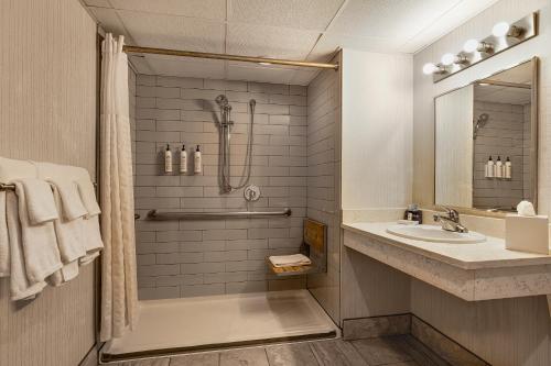 a bathroom with a shower and a sink at Hotel Preston Nashville Airport in Nashville