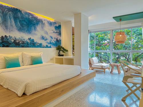 プーケットタウンにあるSino House Phuket Hotel - SHA Plusの壁に絵が飾られた大きなベッドのある寝室