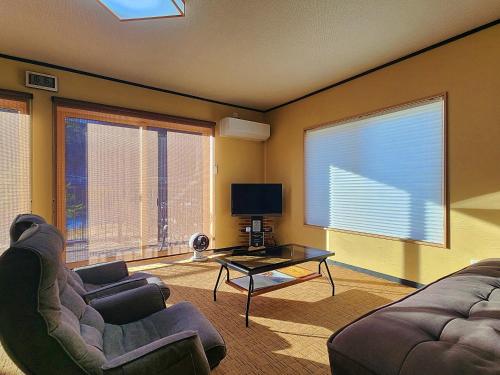 a living room with two couches and a tv at Oyado Katsu in Nagiso