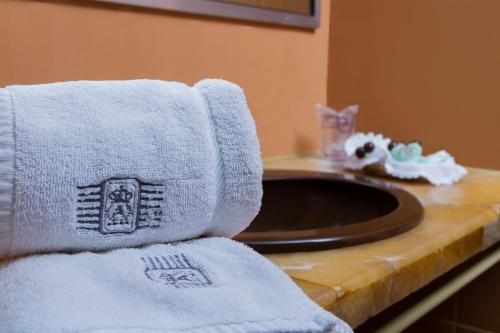 uma casa de banho com toalhas num balcão ao lado de um lavatório em Gran Hotel Ambassador em Cochabamba