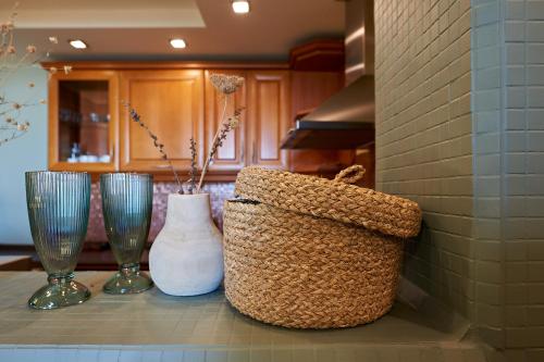 a kitchen counter with three vases and a basket on it at Guest House Dima in Sozopol