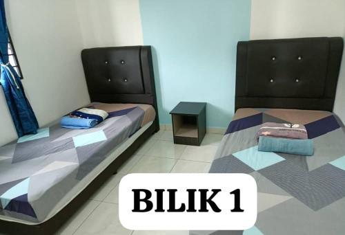 two beds sitting next to each other in a room at SaFa HOMESTAY PULAU INDAH in Pulau Indah