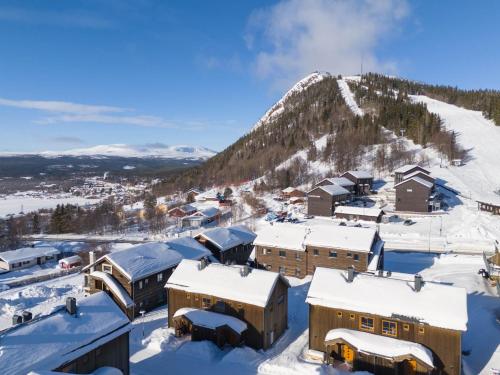 a town covered in snow with a mountain in the background at Funäsdalsporten Funäsdalen in Funäsdalen