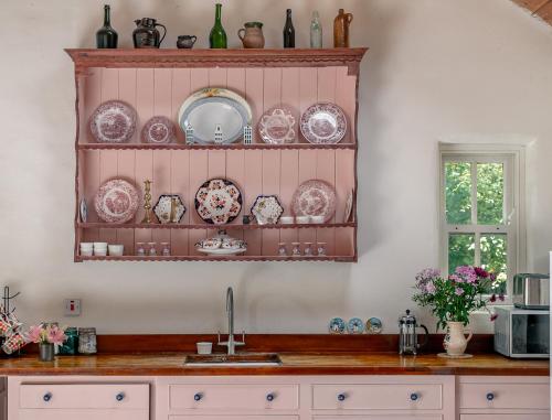 a kitchen with a counter with plates and a sink at Traditional style thatched cottage in Kenmare in Kenmare