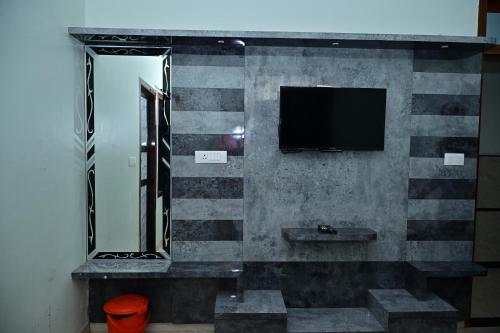 a bathroom with a mirror and a tv on a wall at Hotel Radha Palace & Restaurant in Khātu