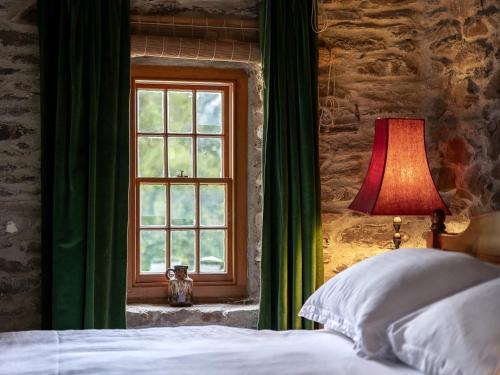 a bedroom with a bed and a window at Traditional style thatched cottage in Kenmare in Kenmare