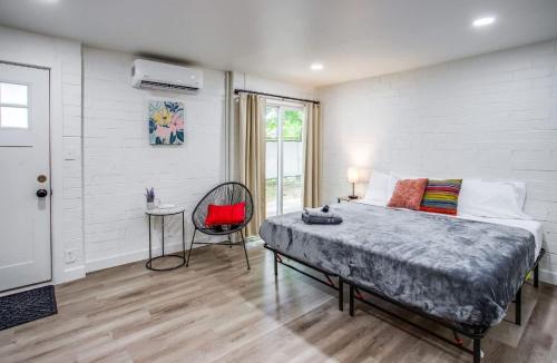 a bedroom with a large bed and a red chair at Newly Renovated Bright Studio in Rochester