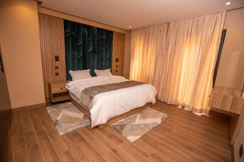 a bedroom with a bed and a large window at Élégance et Prestige à Gueliz Appartement 3 chambres in Marrakech