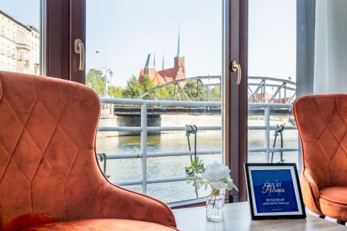 a book sitting on a table in front of a window at Great Polonia River Boat Apartments Wrocław in Wrocław