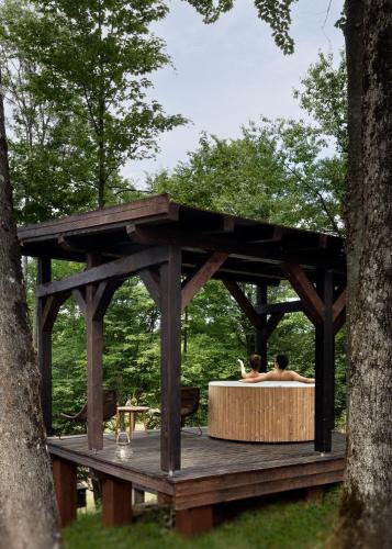 a wooden gazebo with two people in a hot tub at Equilibrium Villa Relais in Rakovica