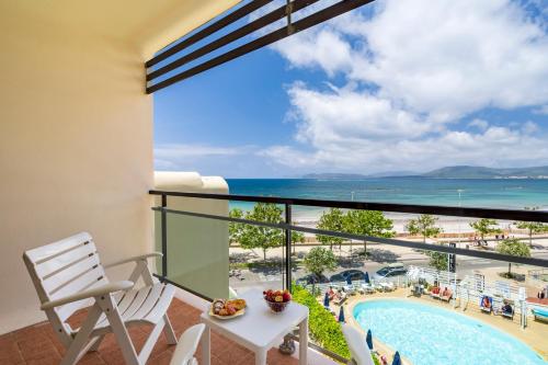 a balcony with a view of a pool and the ocean at Hotel Florida in Alghero