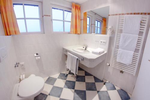 a white bathroom with a sink and a toilet at Ferienhotel Starennest in Schindelberg