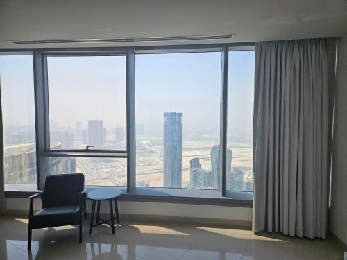 a room with a chair and a table in front of a window at C-Suite Views at Al Reem and Al Maryah Island in Abu Dhabi