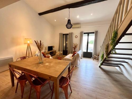 un salon avec une table et des chaises en bois dans l'établissement Grand logements - 3 chambres, à Perpignan