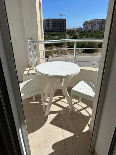 a white table and two chairs on a balcony at Luxueux appt jardin de Carthage in La Goulette