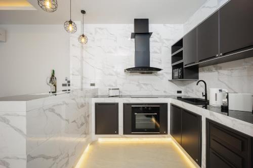 a kitchen with black and white marble counter tops at Barringtonia pool villa in Phuket Town