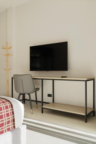 a living room with a television and a chair at Barringtonia pool villa in Phuket Town