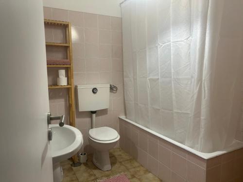 a bathroom with a toilet and a tub and a sink at Casa Moledo in Moledo