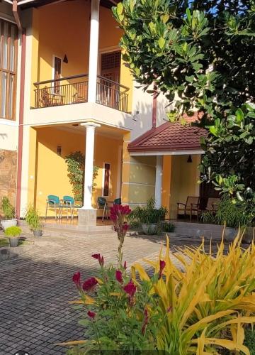 a building with chairs and flowers in a courtyard at Bigcity Villa - Airport Transit Hotel in Katunayake
