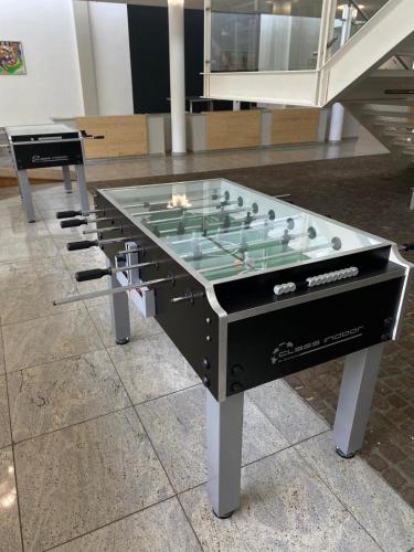 a large glass foosball table in a room at Sportschule Oberhaching in Oberhaching