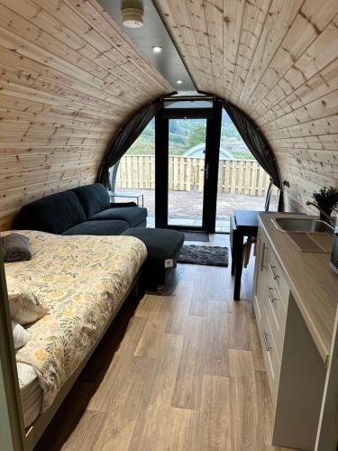 a room with a bed and a table and a kitchen at Fernhill Valley Farm in Blaencwm