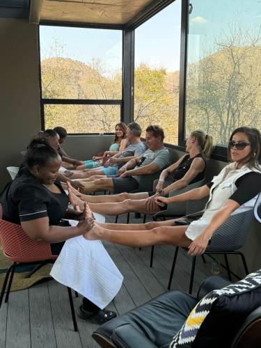 a group of people sitting in a train holding their legs at Umoya Safari Lodge in Matlhagame