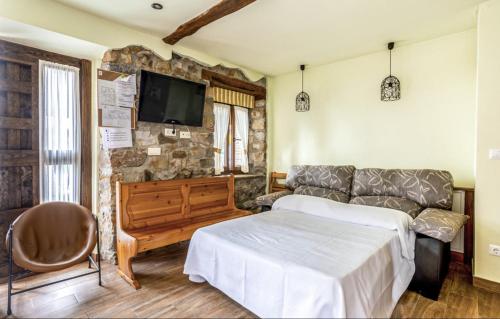 a living room with a bed and a couch at La Tienda de Abajo - Apartamentos para familias con parking privado y vistas al Valle de Soba in Villar