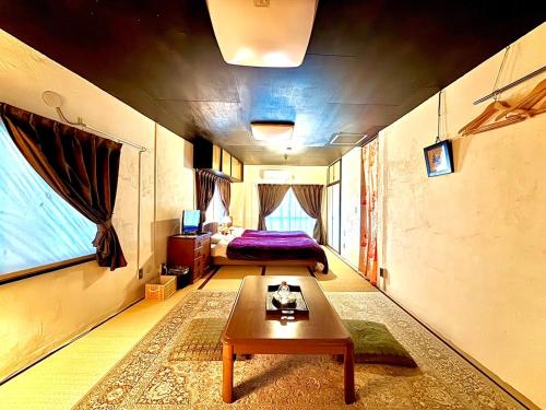 a bedroom with a bed and a table in a room at 酒と宿と不動産-yado- in Yokosuka