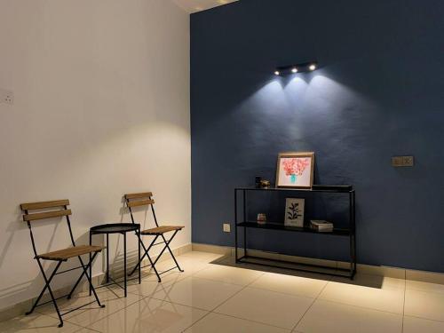 a room with three chairs and a blue wall at Boss Baby Cozy Holiday Home Batu Kawan in Ji Kongsi