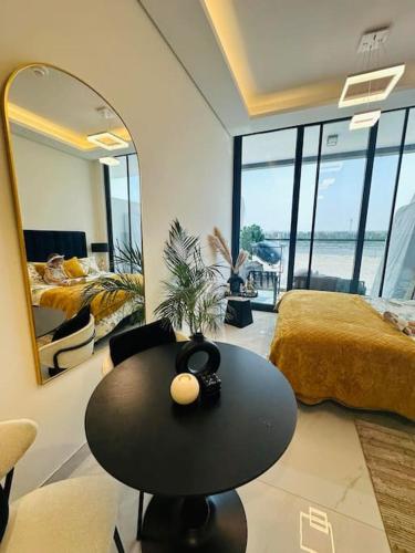a room with a table and a bed and a mirror at Studio entièrement meublé in Dubai
