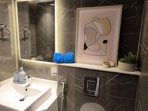 a bathroom with a sink and a picture of a hat at Studio entièrement meublé in Dubai