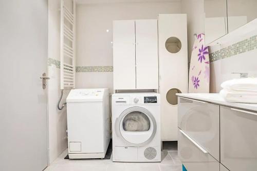 a white laundry room with a washer and dryer at Chez Vélia Grand 4 pièces, parking privé et emplacement idéal in Strasbourg