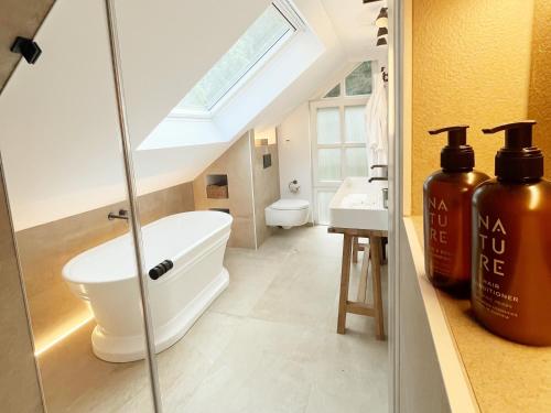 a bathroom with a tub and a toilet and a sink at TauberChalet I Privates Boutique-Ferienhaus mit Whirlpool, Sauna, Garten, Naturmagie & ZellBoost in Rothenburg ob der Tauber