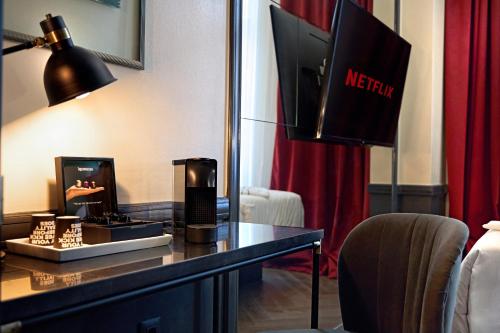 a hotel room with a desk with a television and a mirror at SoHo Athinas 60 in Athens