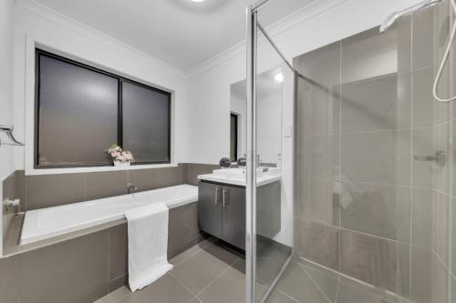 a bathroom with a tub and a sink and a shower at Ensuite Room truganina 20 min CBD Airport in Truganina