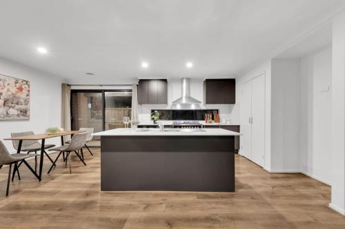 a kitchen with a counter and a table with chairs at Ensuite Room truganina 20 min CBD Airport in Truganina