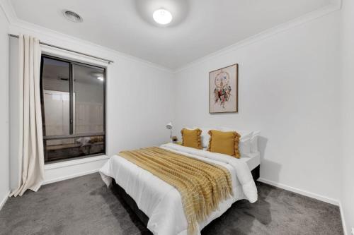 a white bedroom with a bed and a window at Ensuite Room truganina 20 min CBD Airport in Truganina