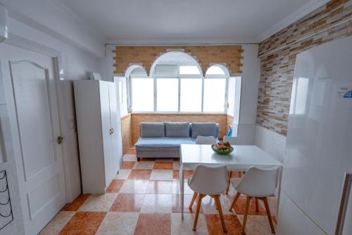 a living room with a table and chairs and a couch at Habitación a 7 mins centro Turístico Torremolinos in Torremolinos