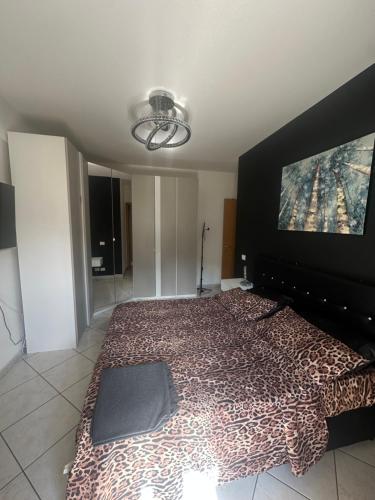a bedroom with a large bed with a cheetah blanket at Appartamento grazioso con giardino in Porto Recanati